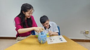 Using an activity-based picture communication board, Clover and Irfan reinforce his understanding and expression.